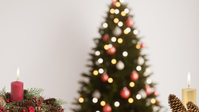 A christmas tree next to lit candles