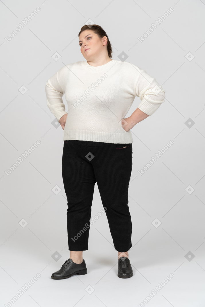 Женщина больших размеров в повседневной одежде стоит с хансом на бедрах