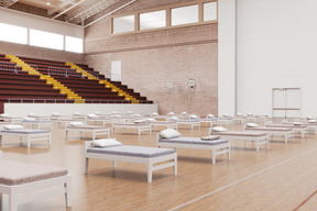 Школьный спортзал с рядами кроватей