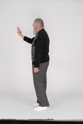 Вид сзади на старика, показывающего два пальца