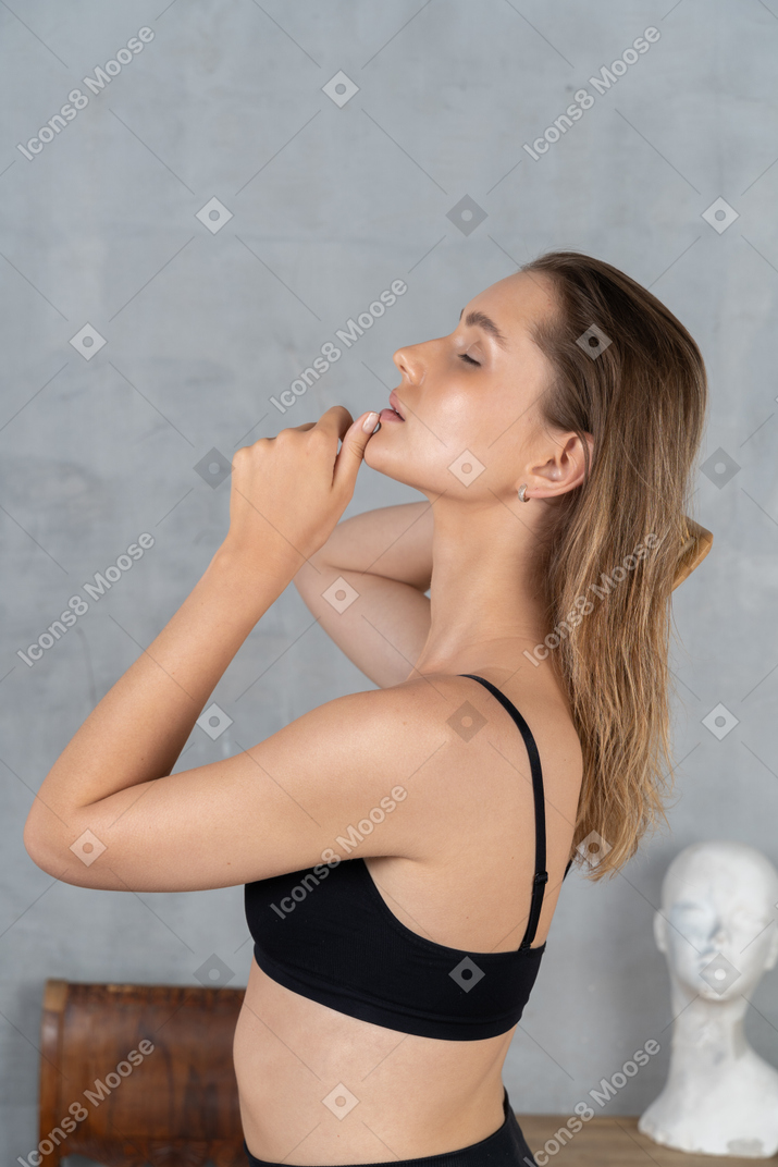 Vue latérale d'une jeune femme se sentant détendue en se brossant les cheveux