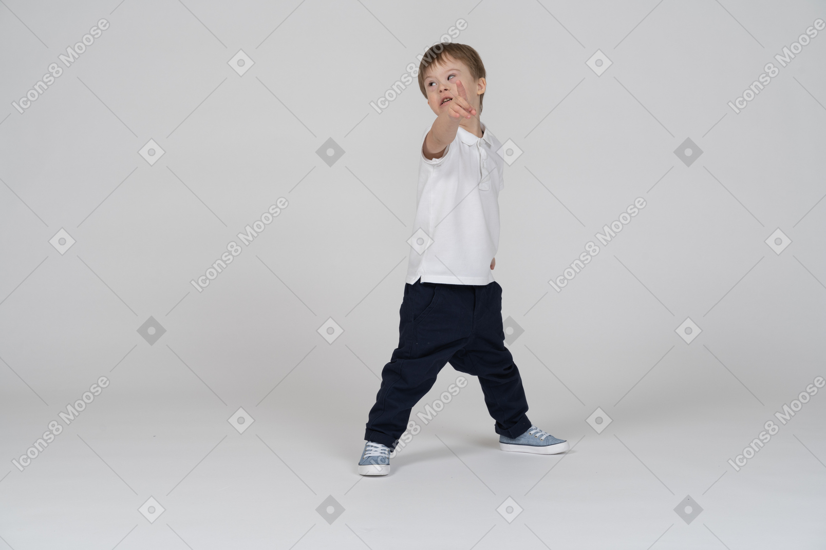 Three-quarter view of a boy pointing at the camera and looking aside