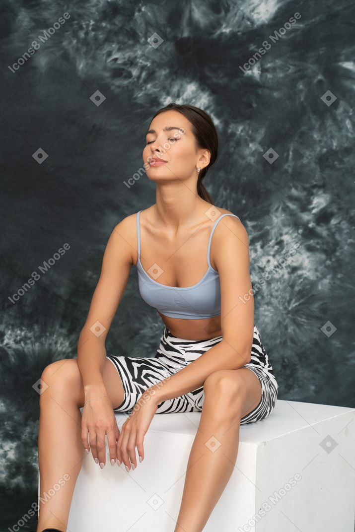 Young female athlete sitting peacefully after workout
