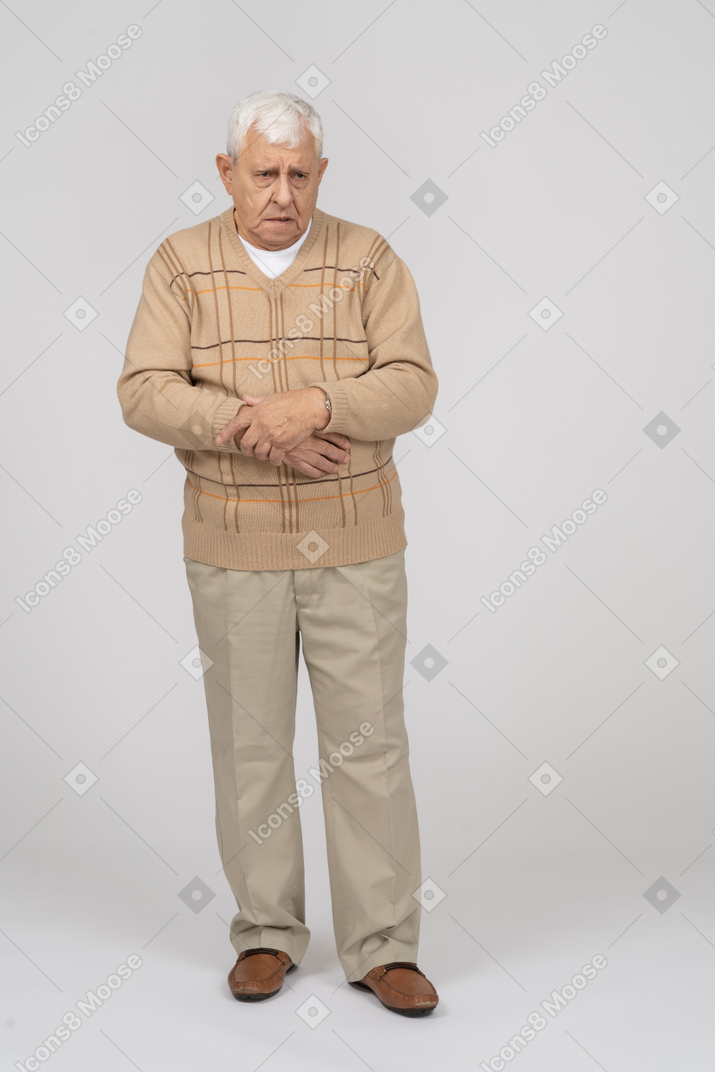 一个穿着休闲服的脾气暴躁的老人看着相机的正面图