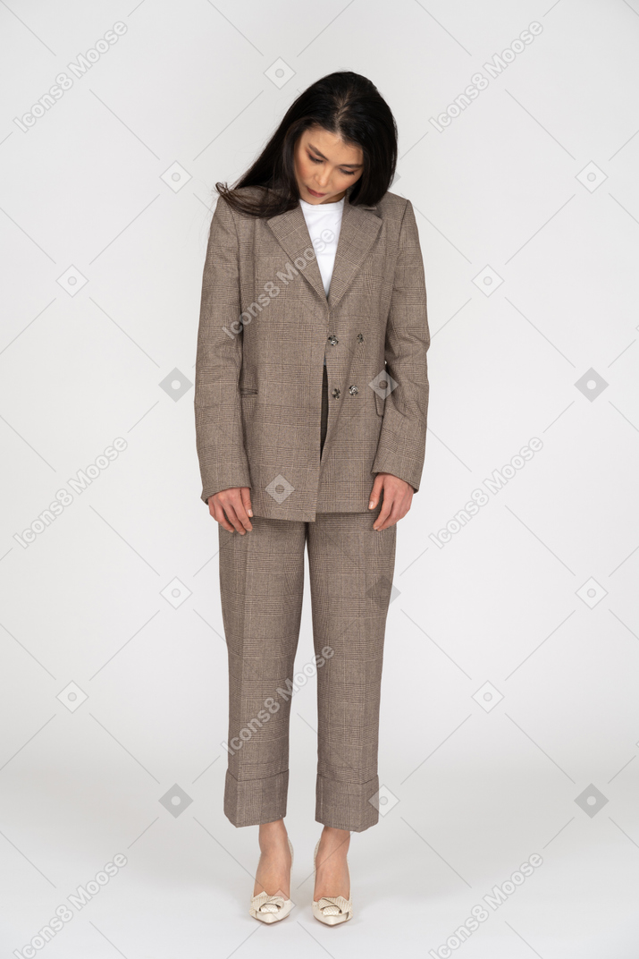 Front view of a young lady in brown business suit looking down