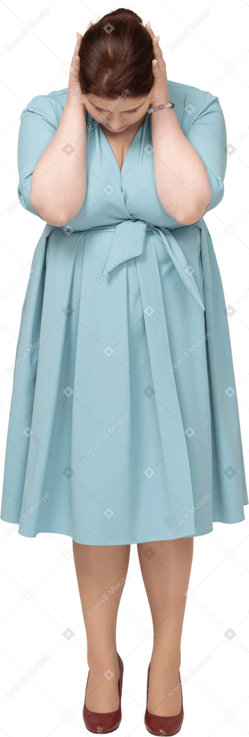 Vue de face d'une femme en robe bleue touchant la tête