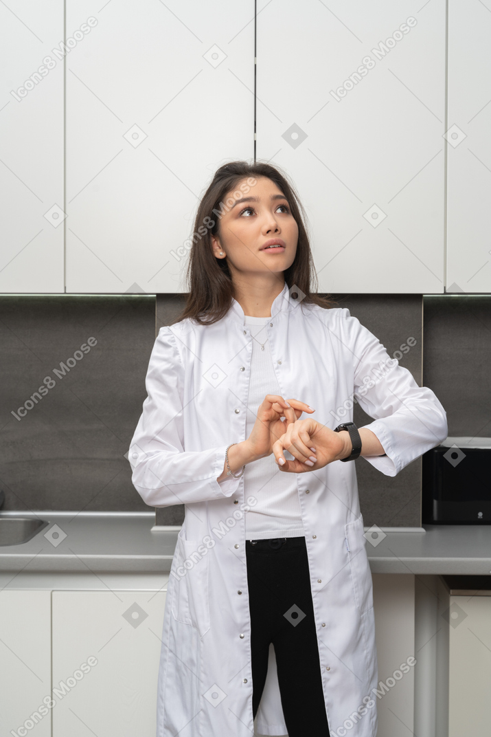 A female nurse looking aside while checking time