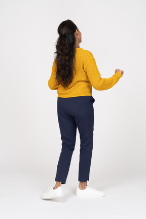 Rear view of a dancing girl in casual clothes