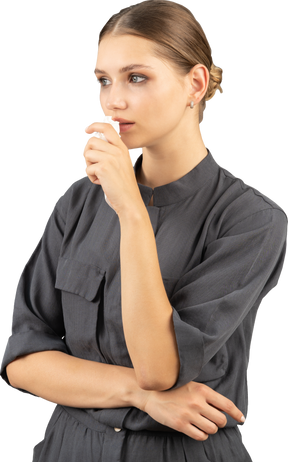 Трехчетвертный вид плачущей молодой женщины в комбинезоне, держащей макияж, снимающей салфетки