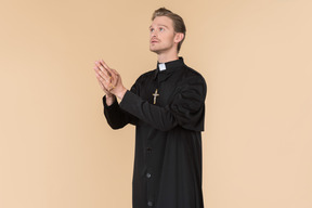 Catholic priest praying using prayer beads