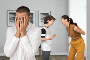 Mom and son are yelling on each other and the man closed face by hands