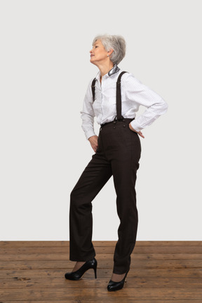 Femme formellement habillée posant avec les mains sur les hanches