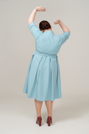 Вид сзади женщины в синем платье танцуют