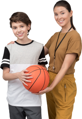 Pe profesor y alumno sosteniendo la pelota de baloncesto