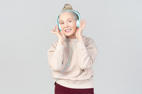 Old lady in listening music in headphones