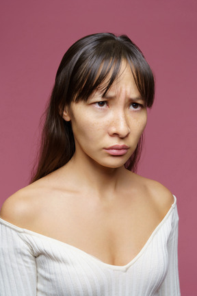 Primo piano di una donna di mezza età dispiaciuta che lavora a maglia sopracciglia e che osserva da parte