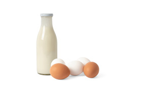 Three eggs and a bottle of milk on a white background