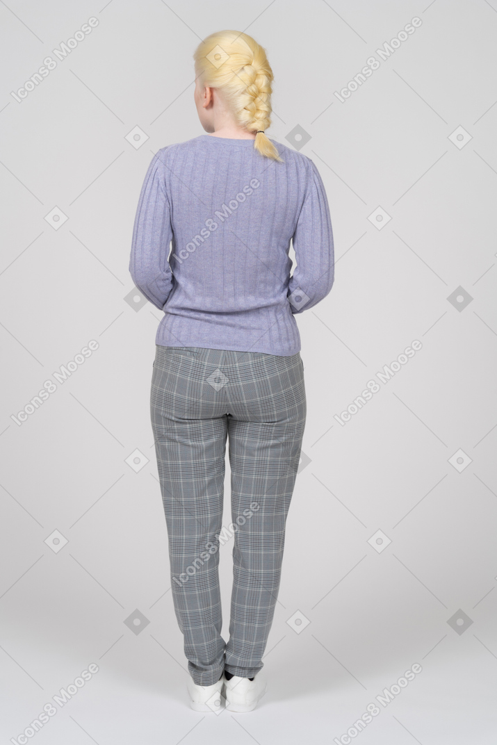 Back view of a young woman in casual clothes looking aside