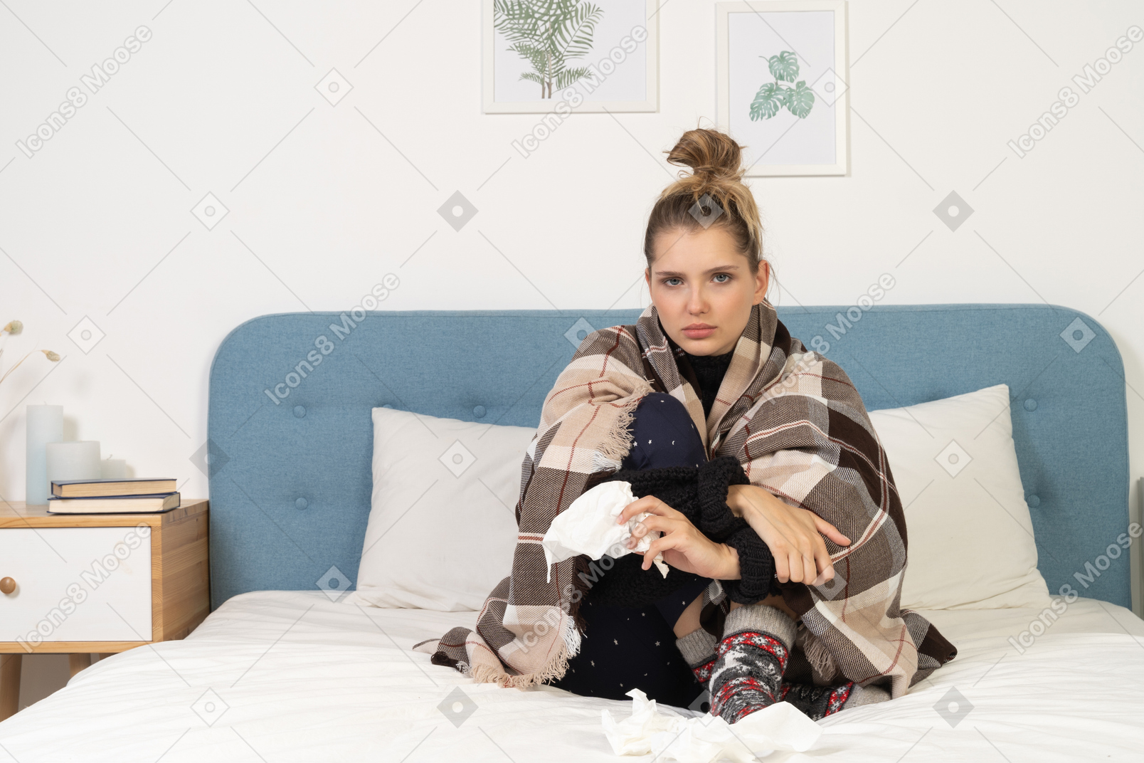 Front view of an ill young lady in pajamas wrapped in checked blanket