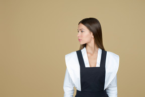 Hermosa mujer en vestido blanco y negro de pie en el perfil