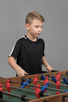 Um garoto jogando uma bola de futebol de mesa