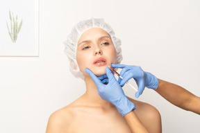 Woman looking upset while getting filler injection