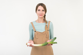 Young woman holding leek onion