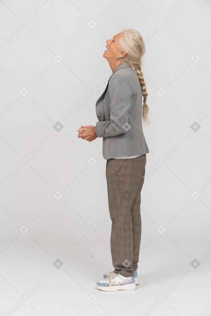 Happy old lady in suit standing in profile
