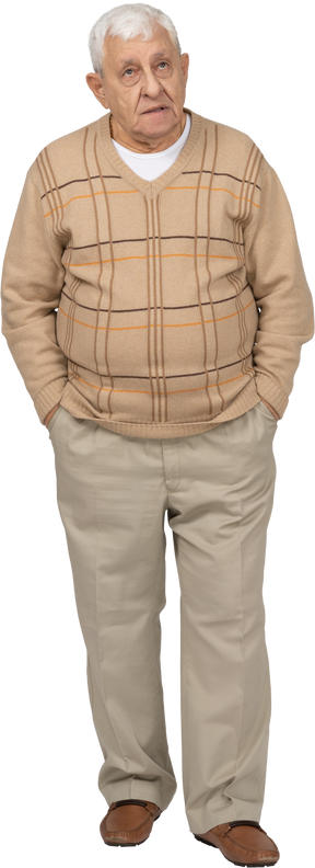 Vista frontal de un anciano con ropa informal de pie con las manos en los bolsillos