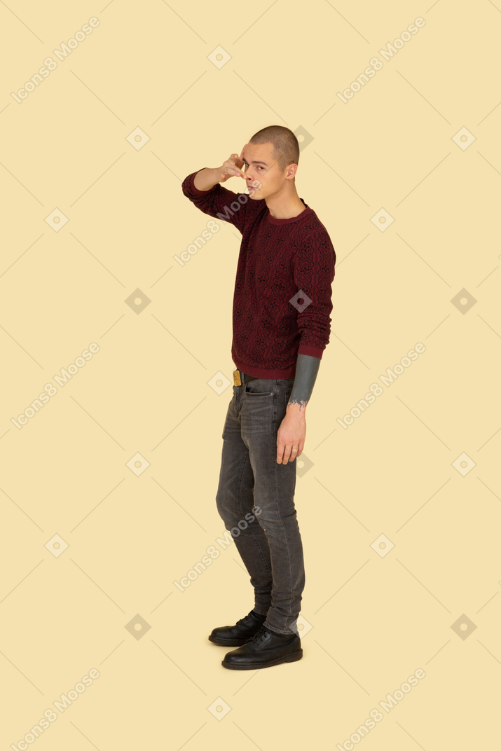 Side view of a funny young man touching his nose