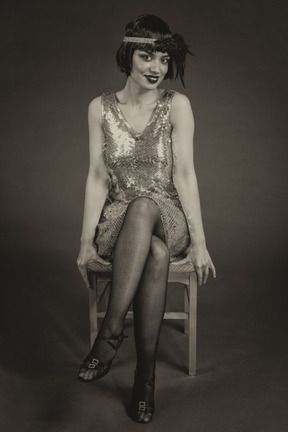 Beautiful american flapper sitting leg to leg on the chair