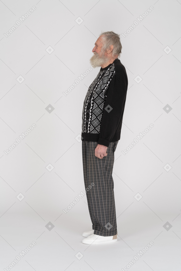 Vista de perfil de un anciano de pie y sonriendo
