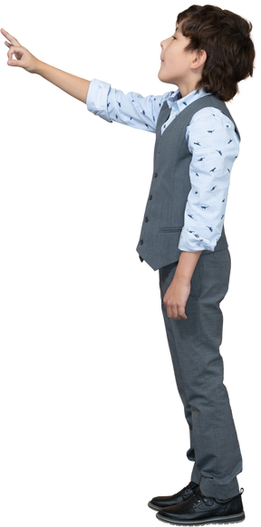 Vista laterale di un ragazzo in abito grigio che mostra segno ok