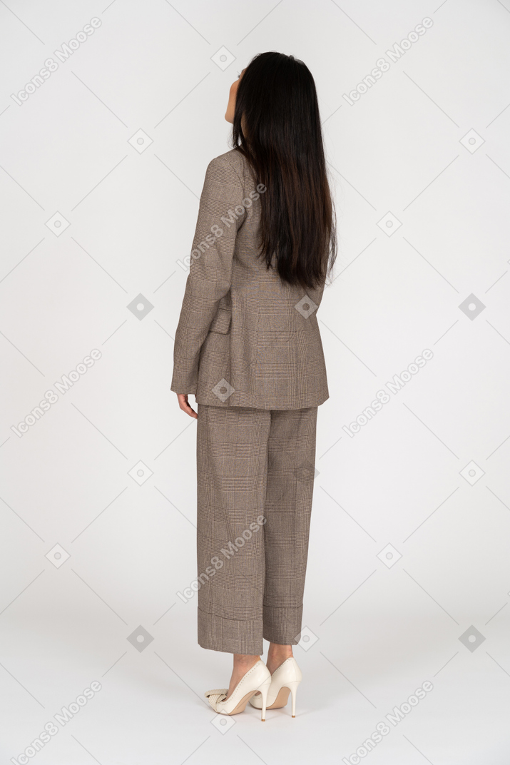 Vista posteriore di tre quarti di una giovane donna in tailleur marrone