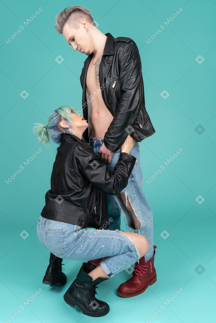 Young woman squatting on haunches in front of her boyfriend