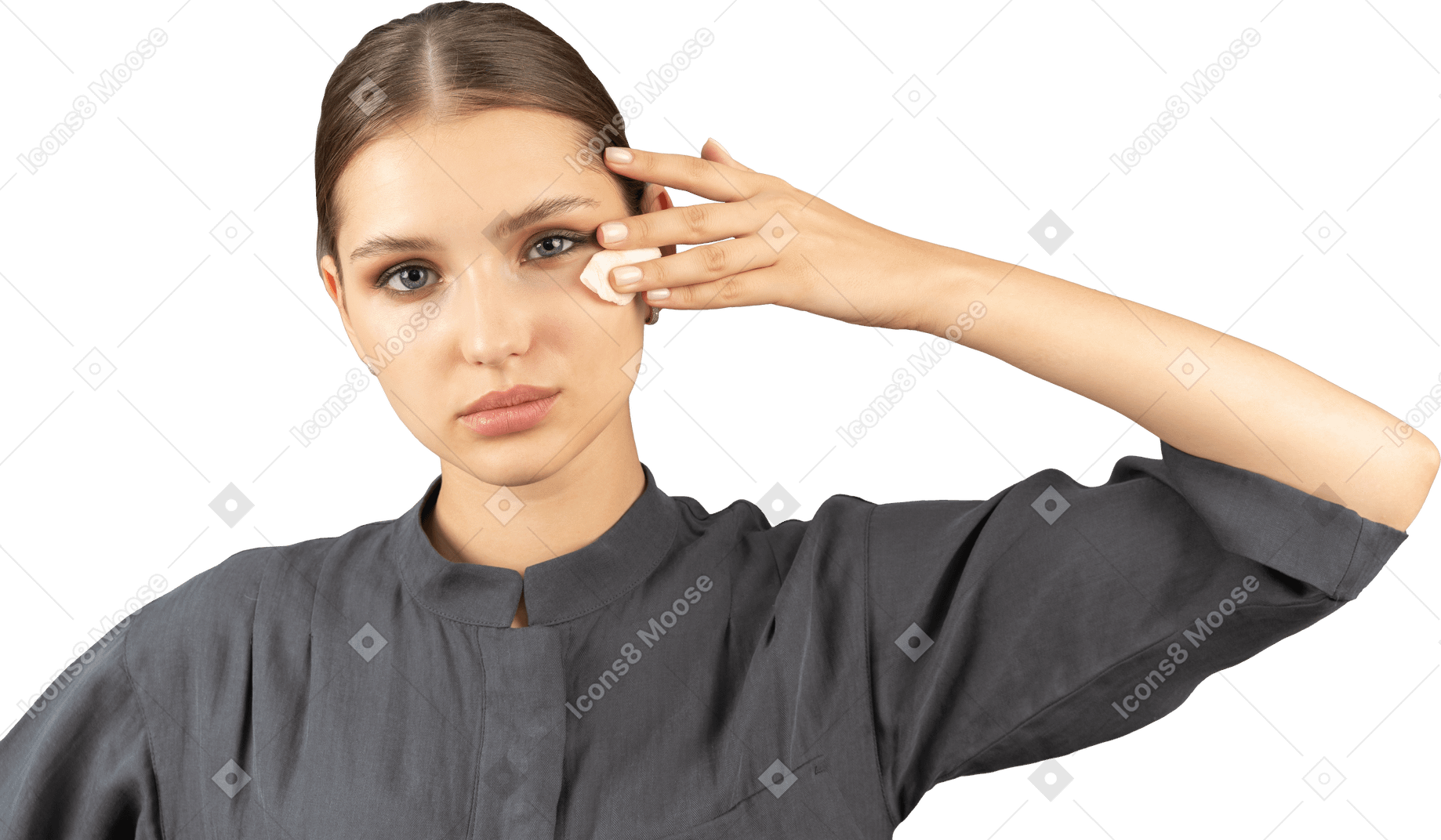 Vista frontal de uma jovem com um macacão removendo a maquiagem