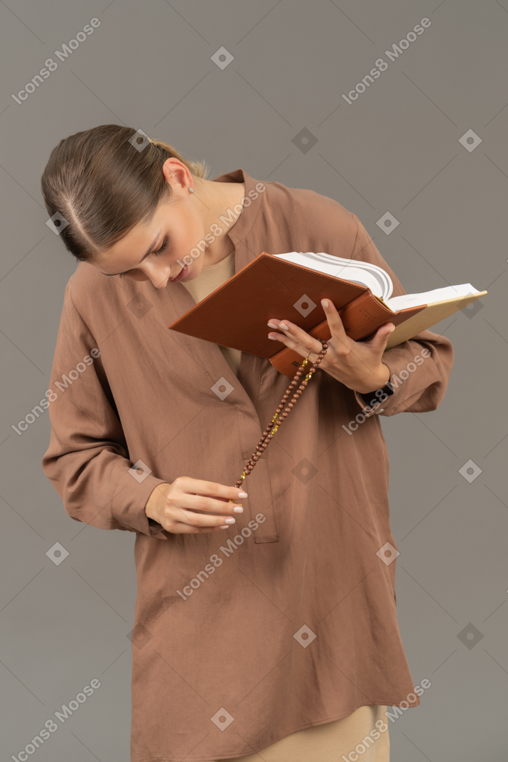 Young woman touching her cross necklace