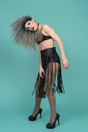 Drag queen en traje negro sacudiendo su cabello