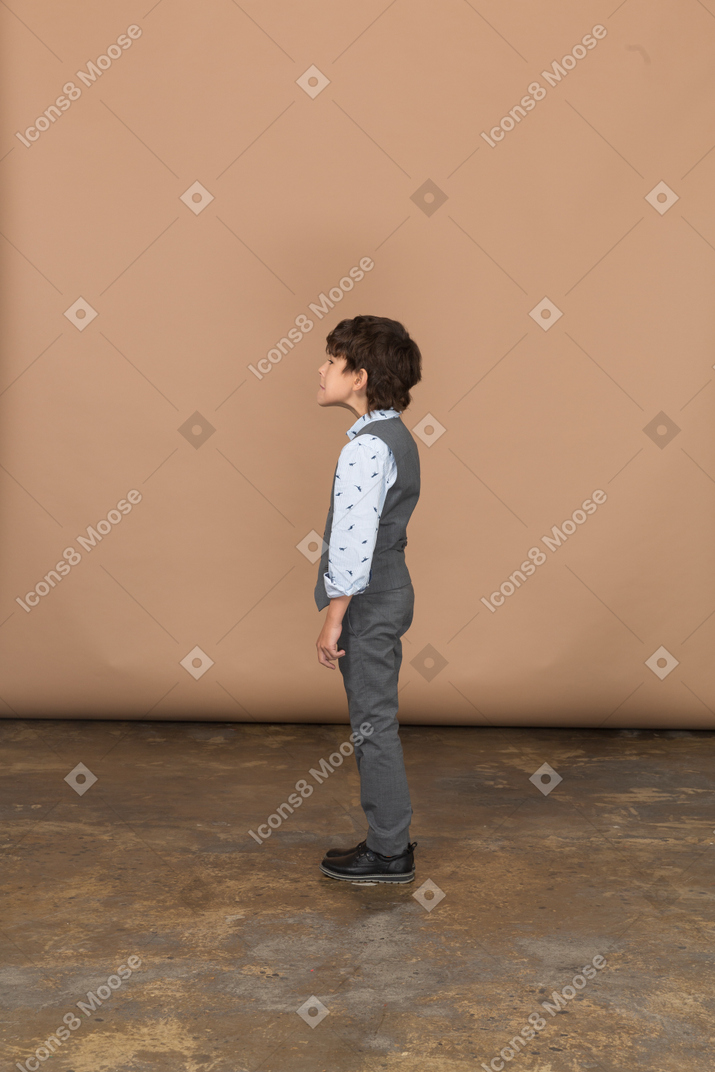 Junge im anzug steht im profil