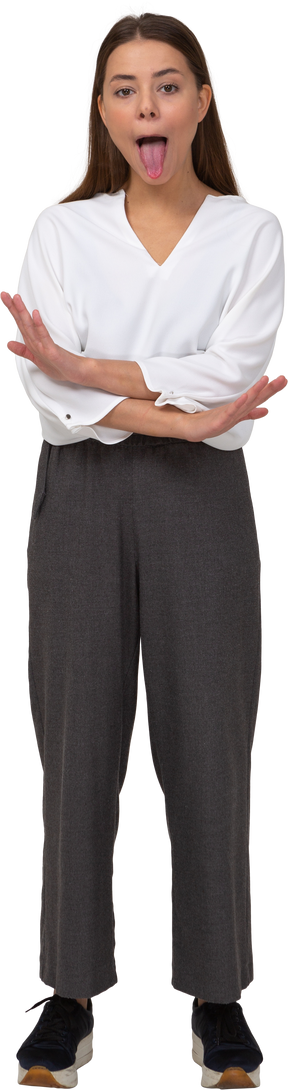 Front view of a young lady in office clothing crossing hands and showing tongue