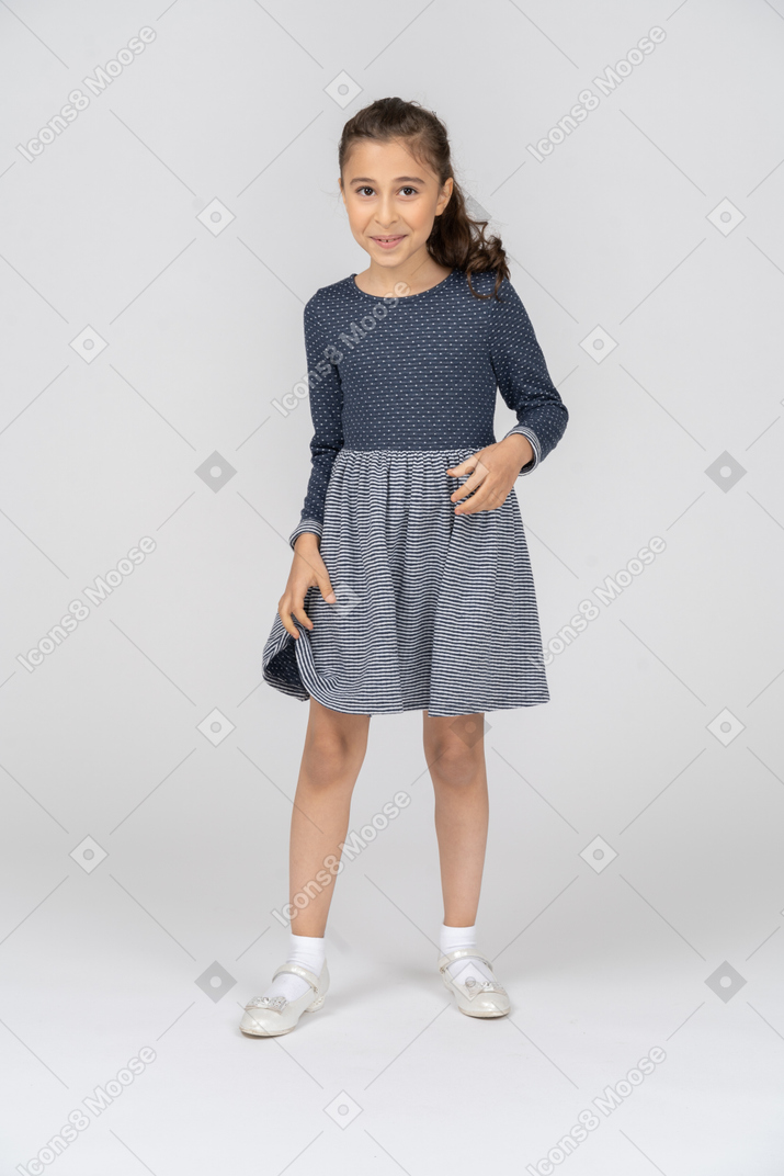 Vista frontal de una niña sonriendo tímidamente y torpemente