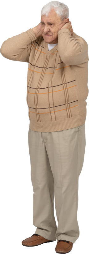 Вид спереди грустного старика в повседневной одежде, закрывающего уши руками