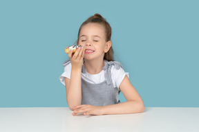 Cute little girl foretasting a doughnut