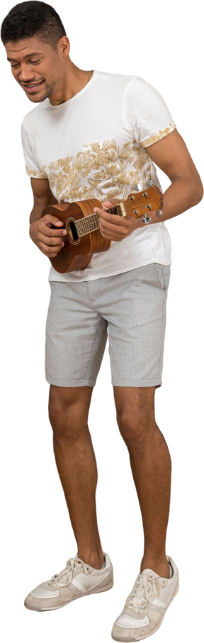 Вид в три четверти на человека, играющего на укулеле