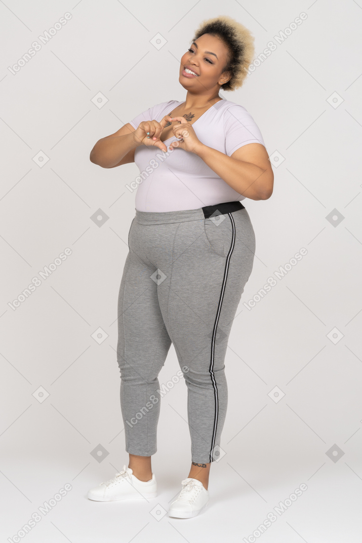 Delighted afro woman showing a heart sign with her fingers