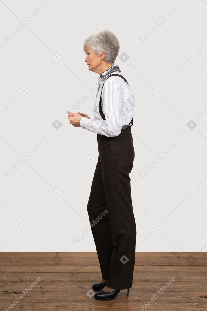 Side view of a sad questioning old lady in office clothing