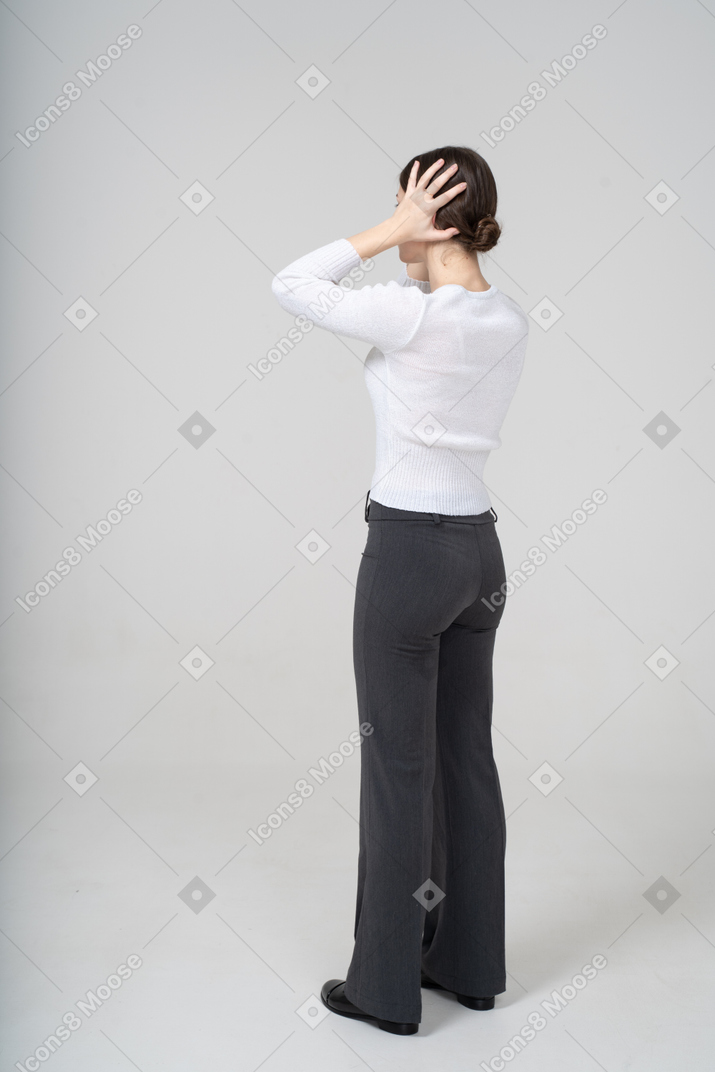 Vista traseira de uma mulher segurando a cabeça com as mãos