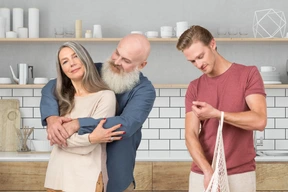 A man standing next to an older couple in the kitchen