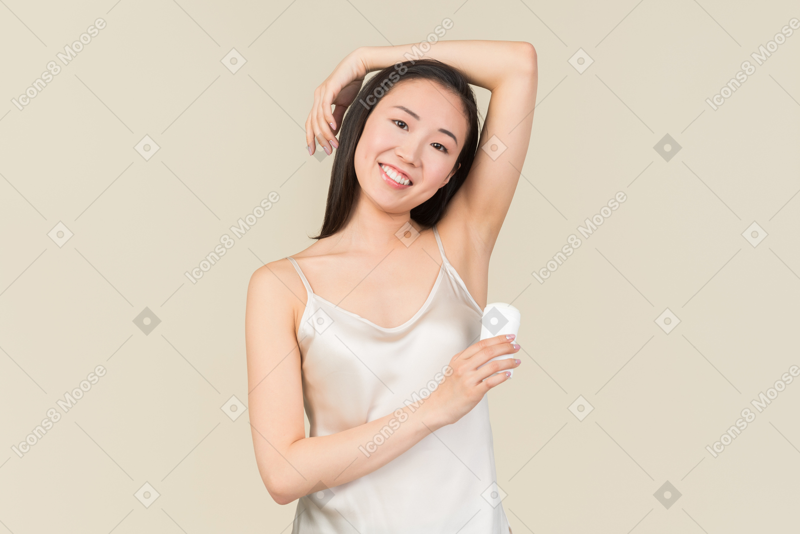 Hübsche asiatische frau deodorant auf achselbereich anwenden