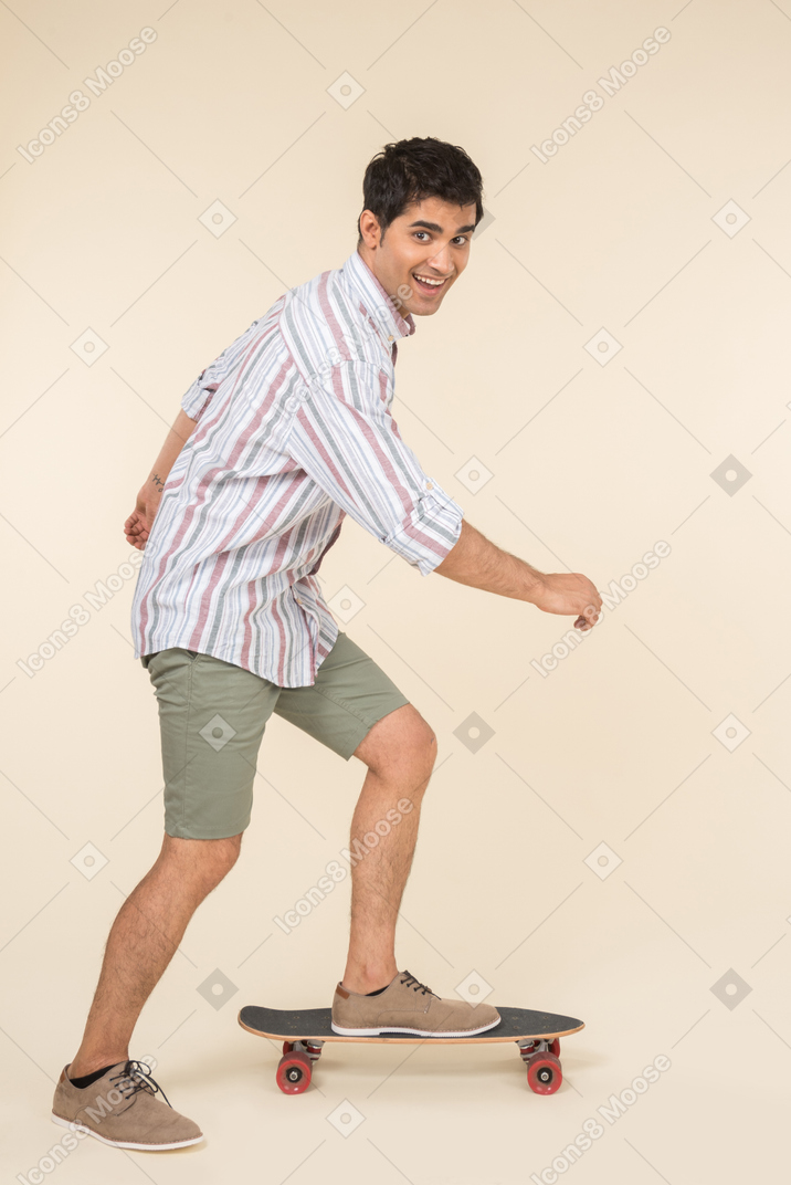 Smiling young caucasian guy standing on skate